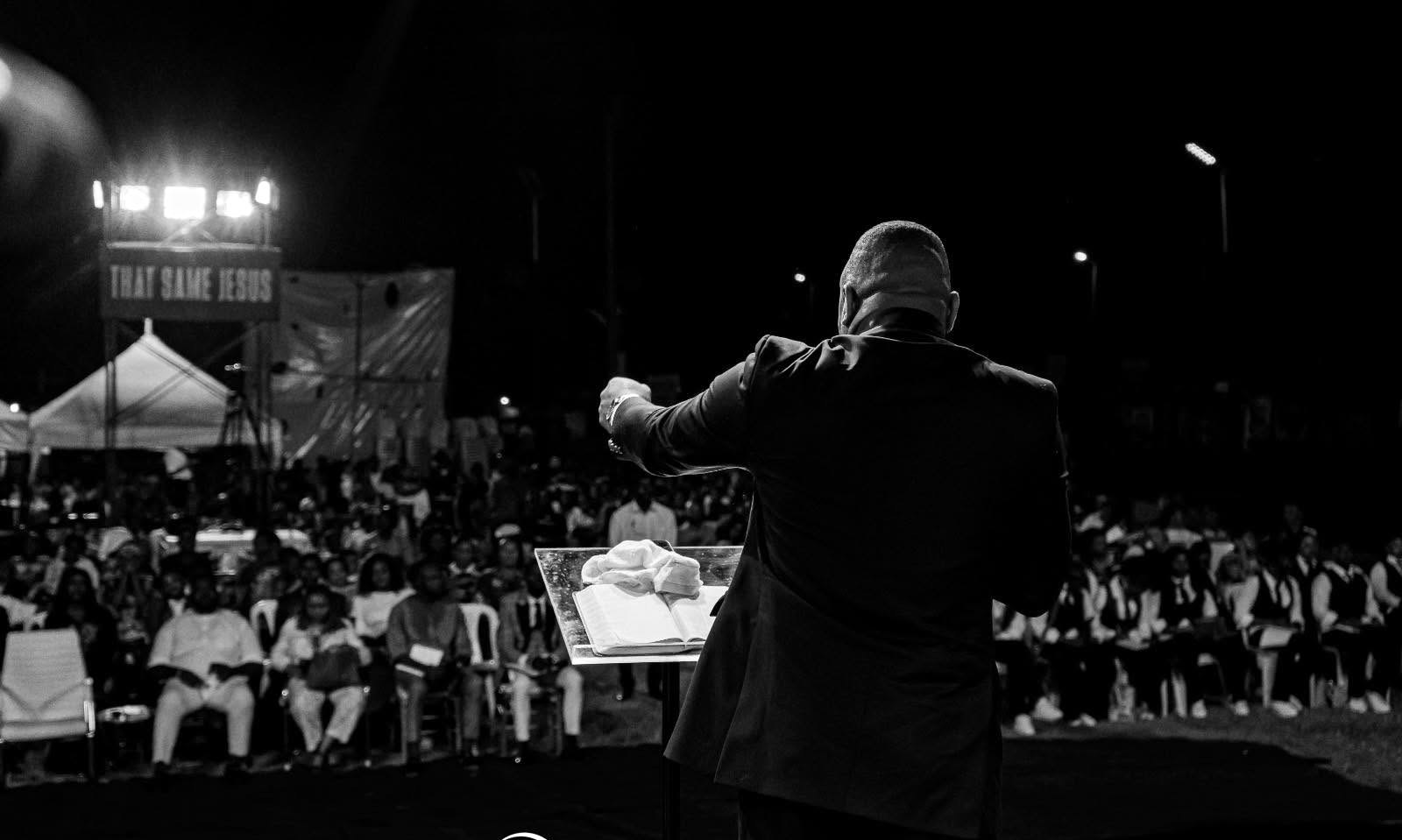 Apostle Sam Onyekachi preaching to a crowd at a That Same Jesus open-air crusade